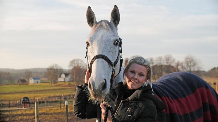 <i>Karin tillsammans med en av stallets yngre hästar, hemma på gården i Vårgårda.</i>